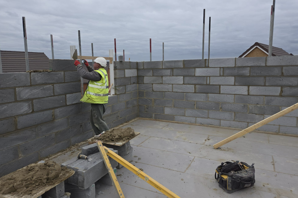 Bricklayer laying lightweight blockwork on a housing site