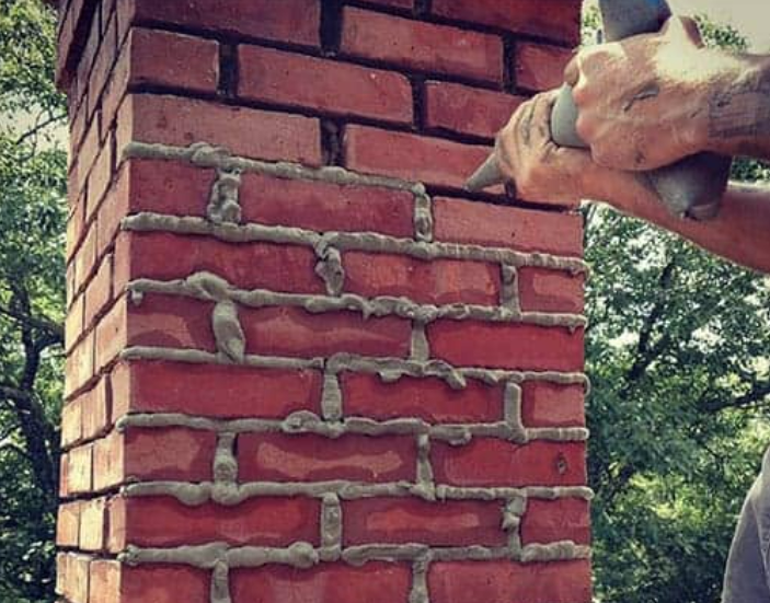 Bagging in fresh mortar joints on a rebuilt chimney stack