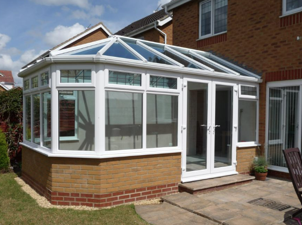Victorian-style conservatory with glass roof on brick base