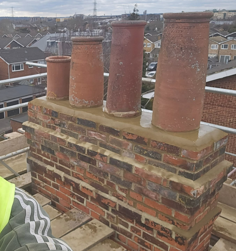 Four matching clay pots re-pointed and re-bedded on a restored chimney