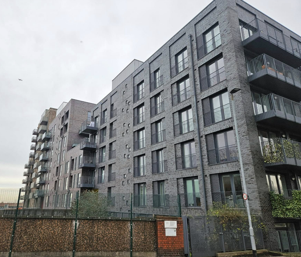 Grey-brick apartment block with privacy screens