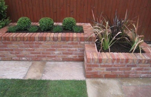 Stepped red-brick raised beds with box hedging and grasses