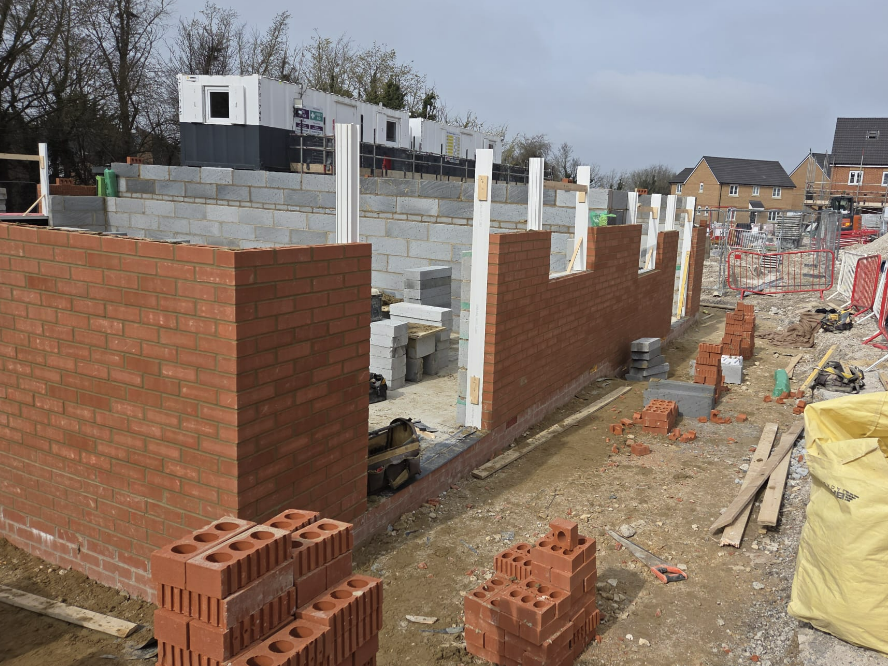 Bricklayers working on a first-floor housing development