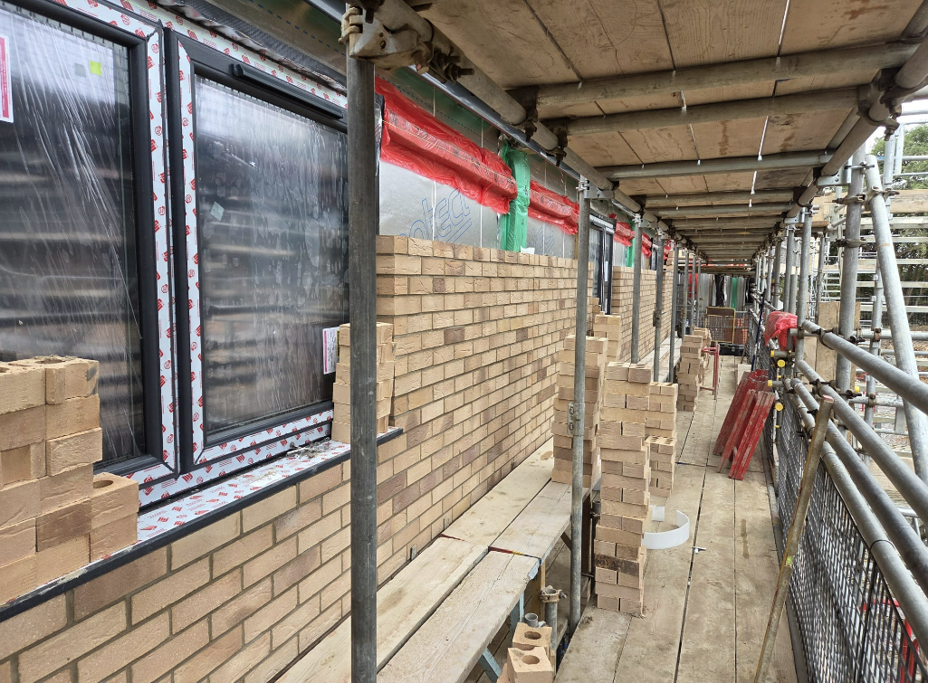 Buff-brick facade work on the flats under scaffold