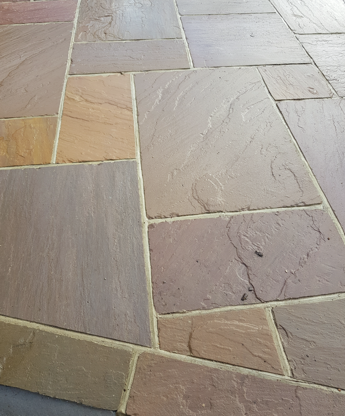 Freshly pointed sandstone patio in mixed warm tones