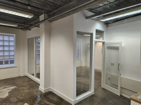 Finished open-plan space with glazed partition doors and skirting