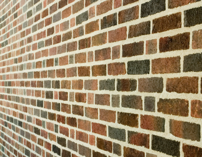 Crisp flush lime pointing across a mixed stock-brick wall