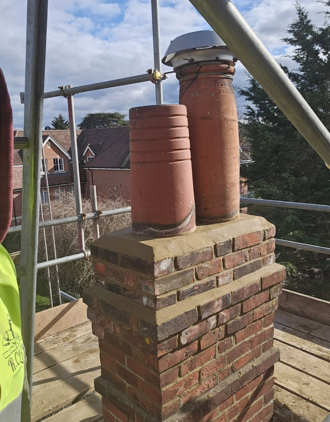 New clay chimney pots bedded on the rebuilt stack
