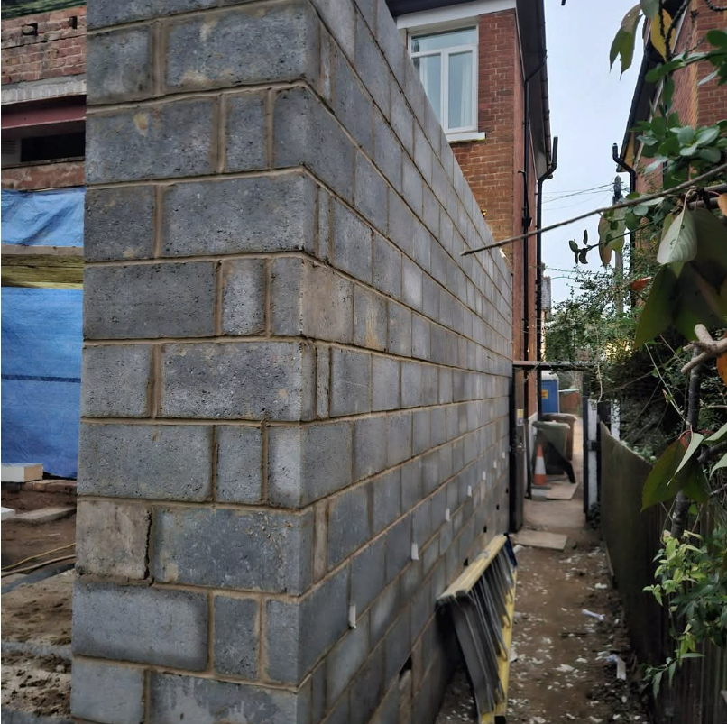 Dense concrete blockwork on an extension side wall