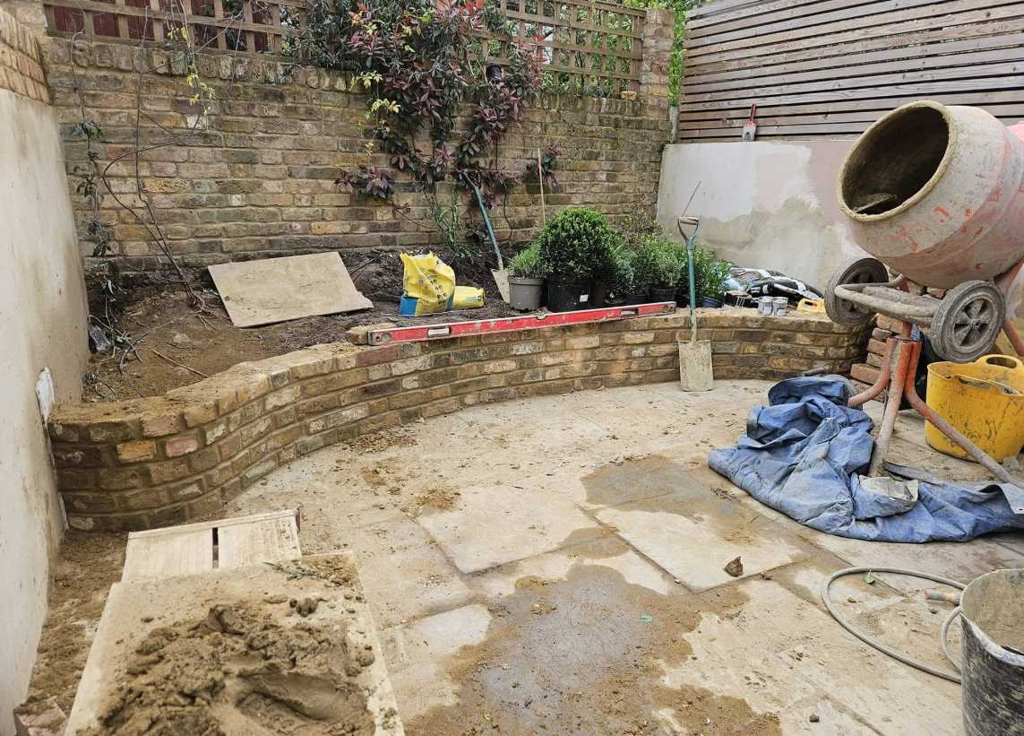Curved stock-brick raised bed wall under construction