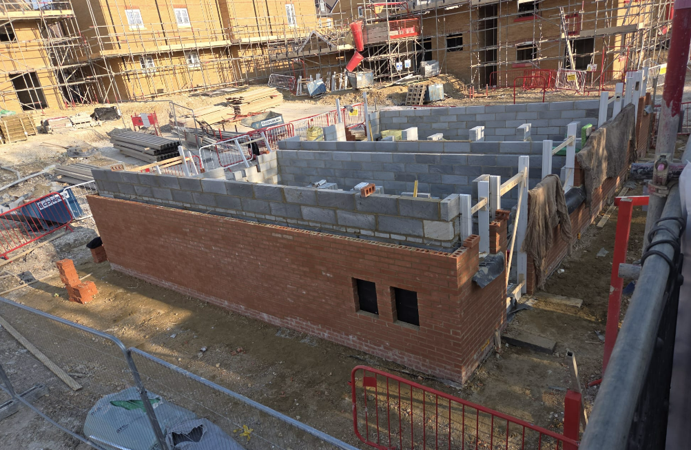 Long brick wall being built on a housing estate
